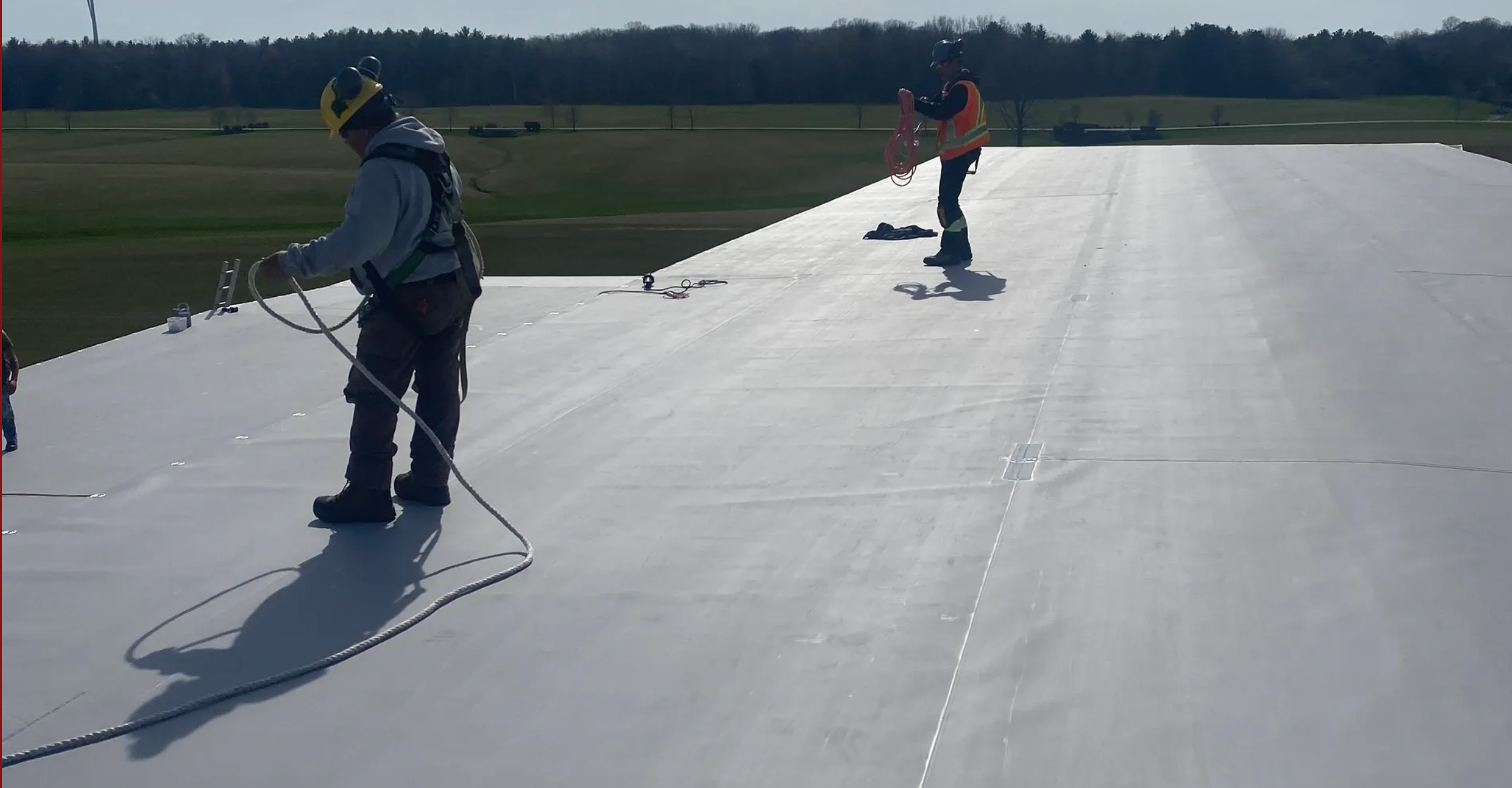 Roofing workers on a single-ply roof