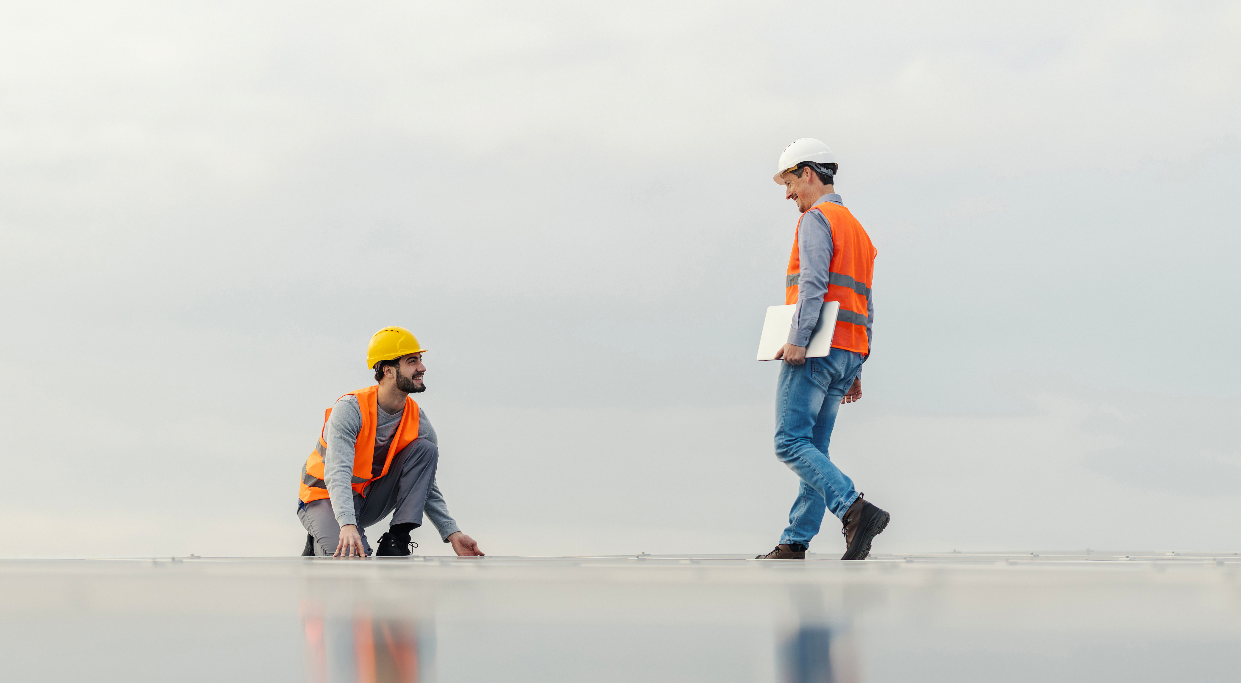 Workers wearing safety vests on a roof
